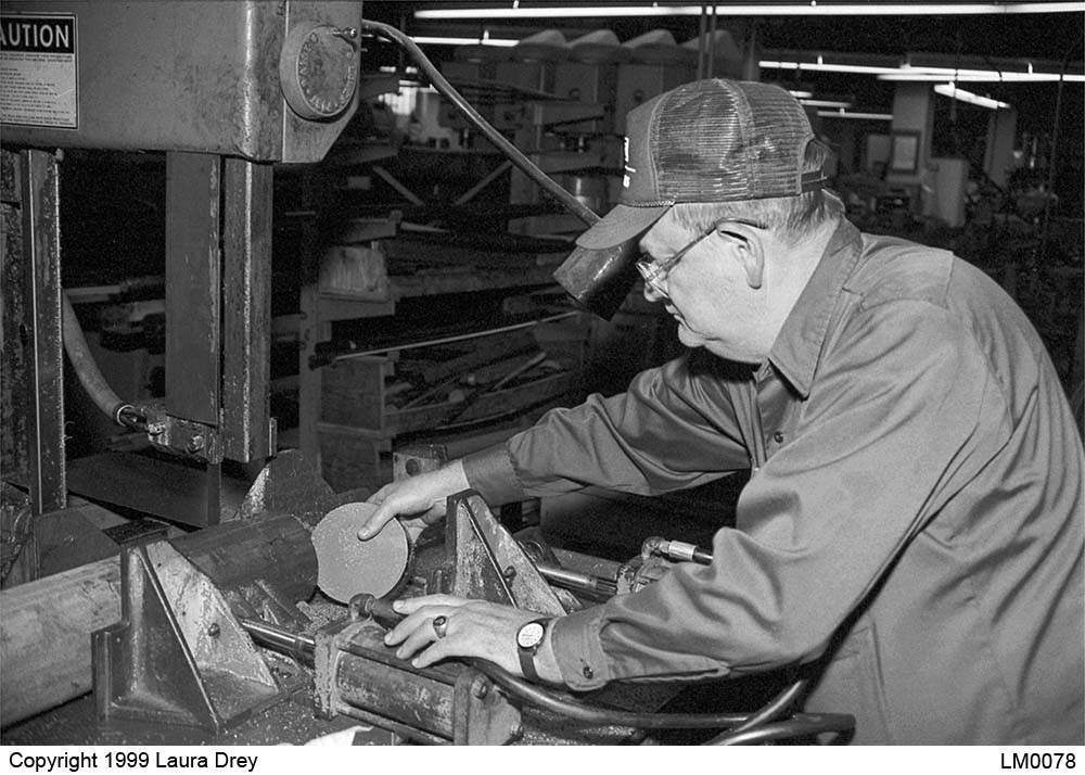 image of machinist operating cut-off saw