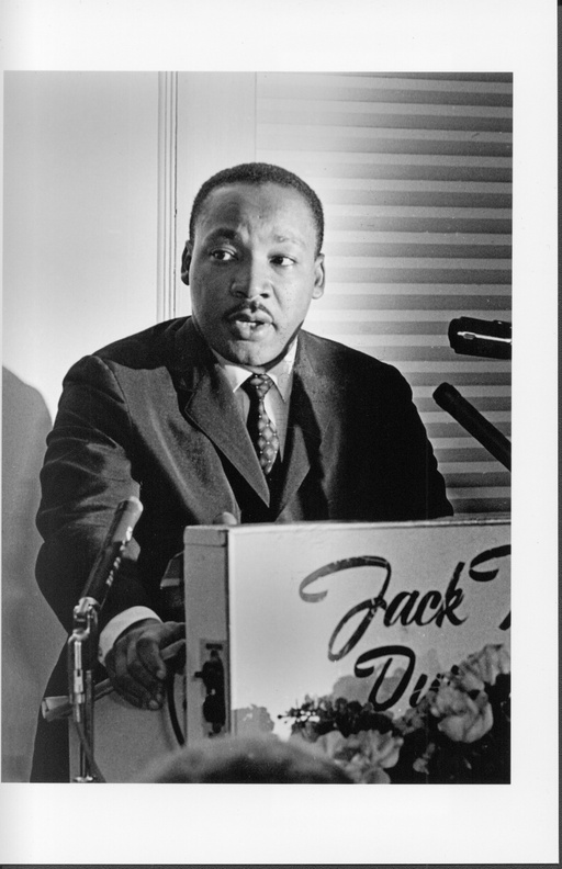 Dr. Martin Luther King standing behind a podium at the Jack Tar Hotel.
