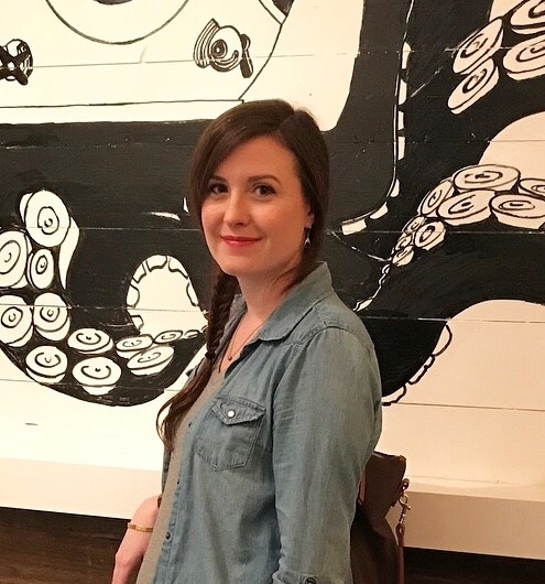 Natalie in front of a black-and-white mural showing some large tentacles