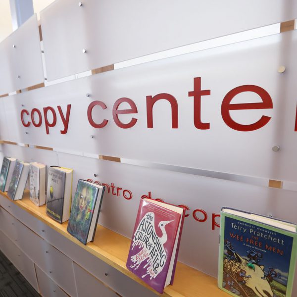 Sign on a low wall saying "copy center," with books set up on a shelf underneath the words