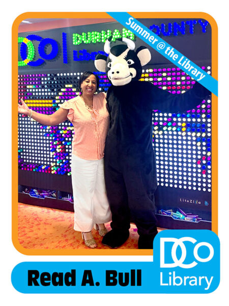 Baseball-style card with picture of costumed mascot Read A. Bull and library director Tammy Baggett in front of a wall-sized light board