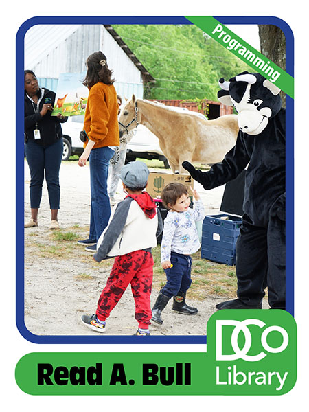 Costumed mascot Read A. Bull with kids and librarians at a horse stable